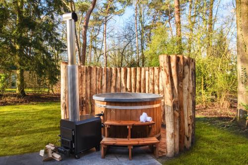 a wood fired stove in a yard next to a fence at Summio Parc Duc de Brabant in Westelbeers