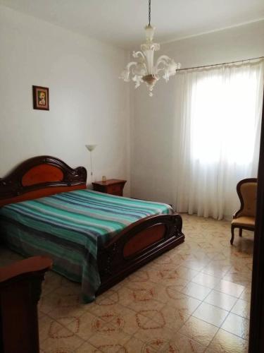 a bedroom with a bed and a chandelier at Villa Giardini in Balestrate