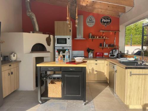 une cuisine aux murs rouges et un comptoir avec évier dans l'établissement Magnifique villa récente entre mer et montagne située entre Ajaccio et Porticcio, à Cauro