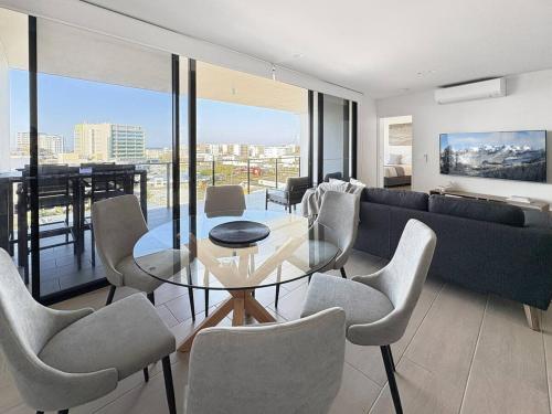 a living room with a glass table and chairs at Luxury Maroochydore Apartment in Maroochydore