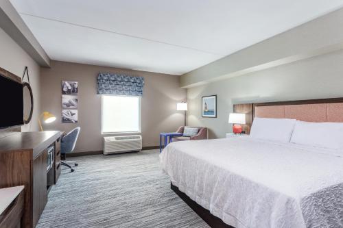 a hotel room with a bed and a television at Hampton Inn & Suites Kittery-Portsmouth in Kittery