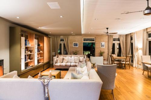 a living room with a white couch and chairs at Angala in Simondium