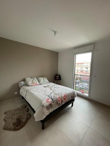 une chambre avec un lit et une grande fenêtre dans l'établissement Appartement 2P Cros de Cagnes à 2 pas de la mer, à Cagnes-sur-Mer