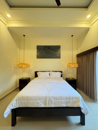 a bedroom with a bed and two lights at Murni’s House in Lovina