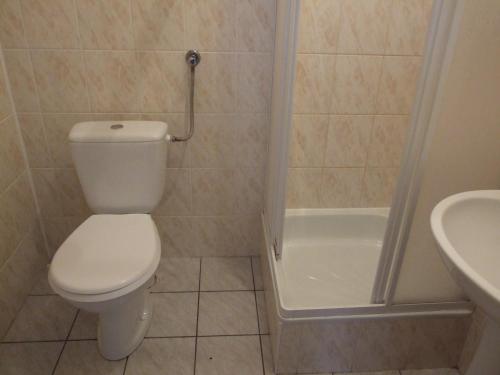 a bathroom with a toilet and a tub and a sink at Gościniec Pogobie in Pogobie Średnie