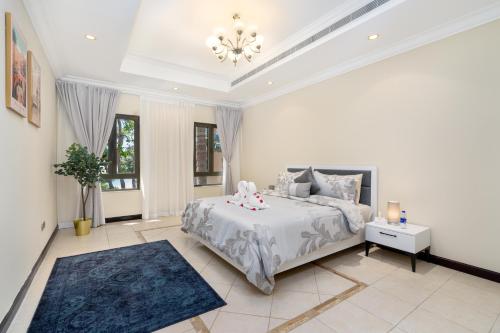 a large bedroom with a bed and a chandelier at Samaya Holiday Homes - Luxury Villa Pool - Beach Access & Fishing Zone in Dubai