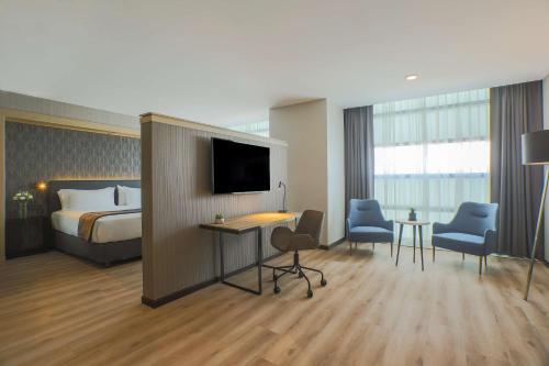 a hotel room with a bed and a television at NH Mexico City Valle Dorado in Mexico City