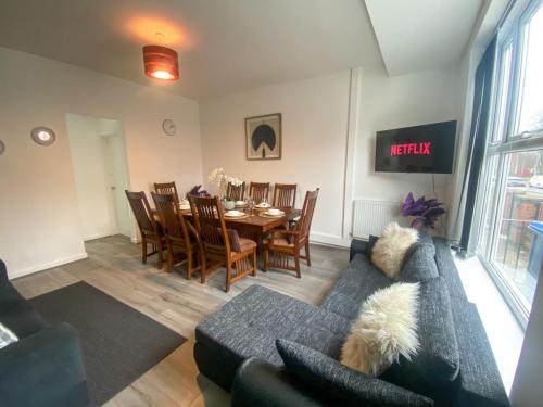 a living room with a couch and a table and chairs at 5 bedroom Luxury Townhouse near City Centre, sleep 16 in Manchester