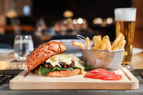 a sandwich and french fries on a table with a glass of beer at NH Mexico City Valle Dorado in Mexico City