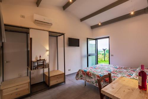 a room with a table and a bed and a table and chairs at Agriturismo Palazzo Bandino - Wine cellar, on reservation restaurant and spa in Chianciano Terme