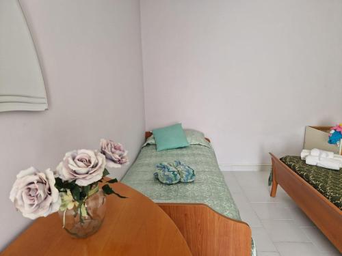 a room with a bed with a vase of flowers on a table at La casetta di Flo in Montecosaro