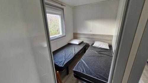 a small room with two beds and a window at Camping Manu in Crots
