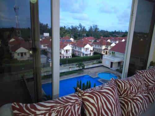 a living room with a couch and a large window at Mtwapa Cozy Apartment by Baharini in Mtwapa