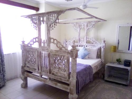 an old wooden canopy bed in a bedroom at Mtwapa Cozy Apartment by Baharini in Mtwapa