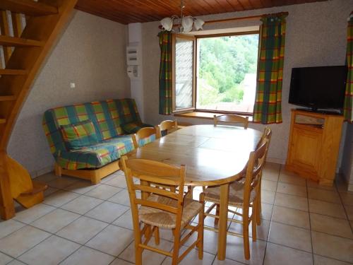 Una sala de estar con una mesa y sillas y un sofá. en Les Oulles 10, en La Chapelle-en-Valgodemard