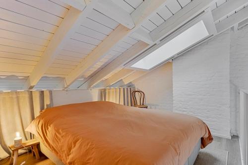 a large bed in a room with a skylight at Loft City Center - 1 bedroom - parking - by FineNest in Liège