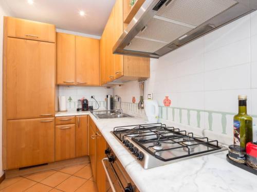 a kitchen with wooden cabinets and a stove top oven at TREVI luxury with terrace in Rome