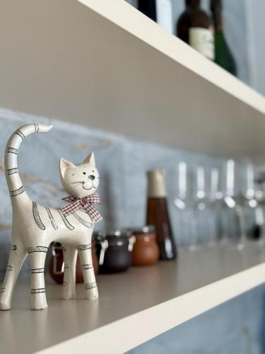a white cat figurine sitting on a shelf at Villa Palacio con Piscina Privada in Puerto Real
