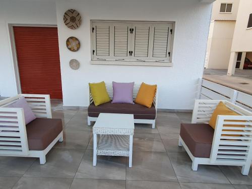 a patio with two chairs and a couch and a table at Makenzy Mermaid 2 Bedroom Apartment in Larnaka