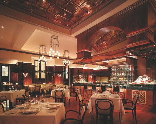 a restaurant with white tables and chairs and a bar at MGM Macau in Macau