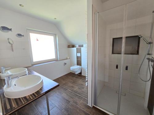 a bathroom with two sinks and a shower at Haus Wiekend - Fewo Strandkrabbe in Wiek auf Rügen 