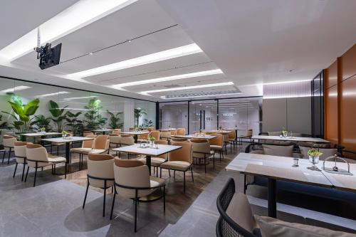 a restaurant with tables and chairs in a room at HomeInn Plus at China Intl Exhibition Center and Liufang Subway Stn in Beijing