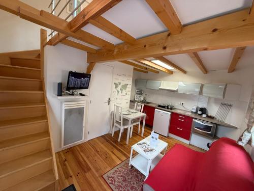 un salon avec un canapé rouge et une cuisine dans l'établissement Escale Belfortaine - Dépendance au calme, à Belfort