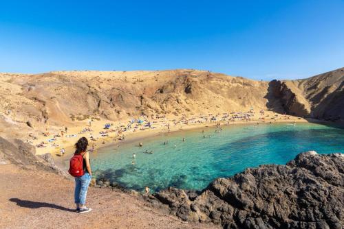 a woman standing on a hill overlooking a beach at Playa Honda Red Suite in Playa Honda