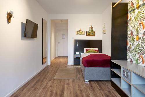 a bedroom with a bed and a flat screen tv at Zur Krone in Neuötting