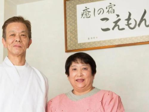 a man and a woman standing in front of a wall at 癒しの宿 こえもん in Kami