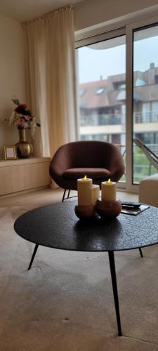 a living room with a table with candles on it at Appartement Wellington D3 Knokke full service et parking in Knokke-Heist