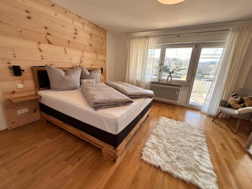 una camera da letto con un letto con una parete in legno di Ferienhaus Muskatellerhof a Silz
