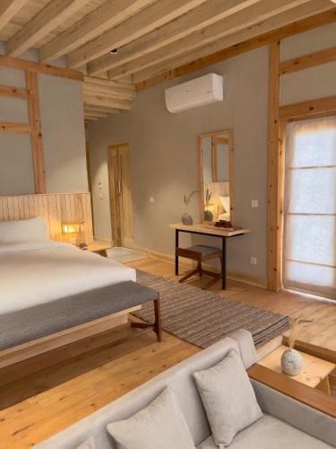 a bedroom with a bed and a couch and a desk at The Rihla Hunza - Managed By Luxus in Hunza