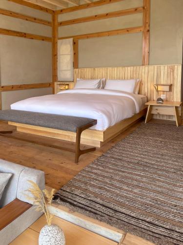 a bedroom with a large white bed and a rug at The Rihla Hunza - Managed By Luxus in Hunza