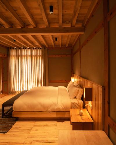 a bedroom with a large bed and a table at The Rihla Hunza - Managed By Luxus in Hunza