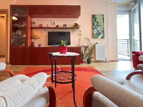 a living room with a table and a tv at Lovely home - Free parking in Budapest