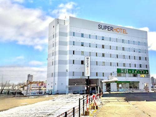 a white building with a super hotel sign on it at Super Hotel Kushiro-Ekimae in Kushiro