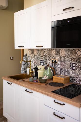 - un comptoir de cuisine avec des placards blancs et un four micro-ondes dans l'établissement Love room La Toscana, à Romans-sur-Isère