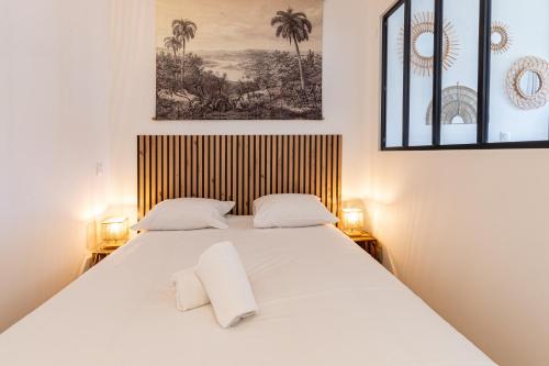 une chambre avec un grand lit blanc avec deux oreillers dans l'établissement Sept îles - studio - centre-ville - TV, à Vannes