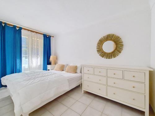 une chambre avec un lit, une commode et un miroir dans l'établissement Appartement de plain pied Le Racou Mar 24, à Argelès-sur-Mer