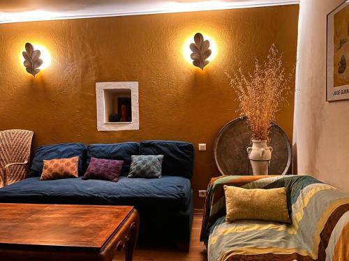 a living room with a blue couch and a table at Le Manou Maison de charme en Drôme provençale in Marsanne