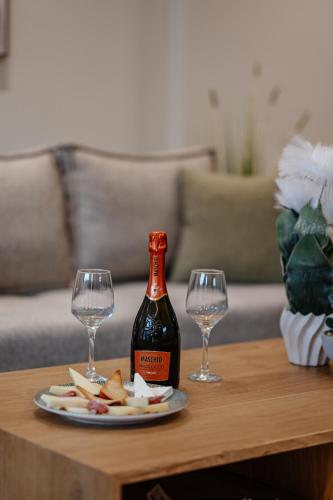a bottle of wine and two wine glasses on a table at 1864 Apartments in Zakynthos