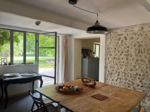 a kitchen with a table with a bowl of fruit on it at Le Manou Maison de charme en Drôme provençale in Marsanne