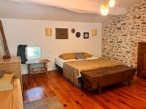 a bedroom with a bed and a brick wall at Le Manou Maison de charme en Drôme provençale in Marsanne