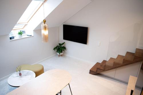 カウナスにあるM 8 apartmentのリビングルーム(テーブル、壁掛けテレビ付)