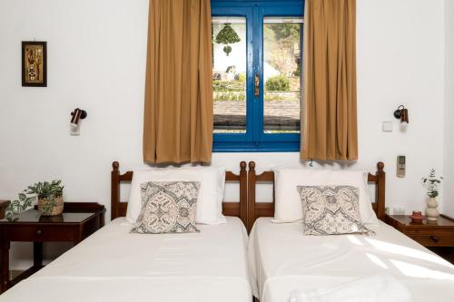Dos camas en una habitación con ventana. en Villa Panorama in Pefkos, en Pefki