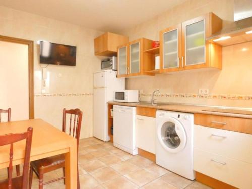 a kitchen with a washing machine and a table at Lar de María in Villacastín
