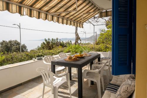 Una mesa y sillas en un balcón con vista. en Villa Panorama in Pefkos, en Pefki