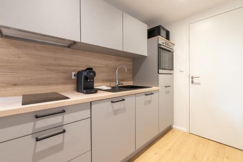 une cuisine avec des armoires blanches et un évier dans l'établissement Belle île en mer - centre-ville - T2 - Wifi, à Vannes