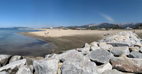 un groupe de rochers sur une plage près de l'eau dans l'établissement ISA- Holiday Home Il Pontile in Marina di Massa, apartments with private outdoor area, just 400 meters from the beach, à Marina di Massa